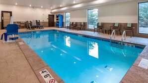 A swimming pool with clear water, a 4'6" depth marking, and a blue chair by the poolside.