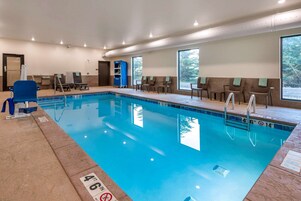 A swimming pool with clear water, a 4'6" depth marking, and a blue chair by the poolside.