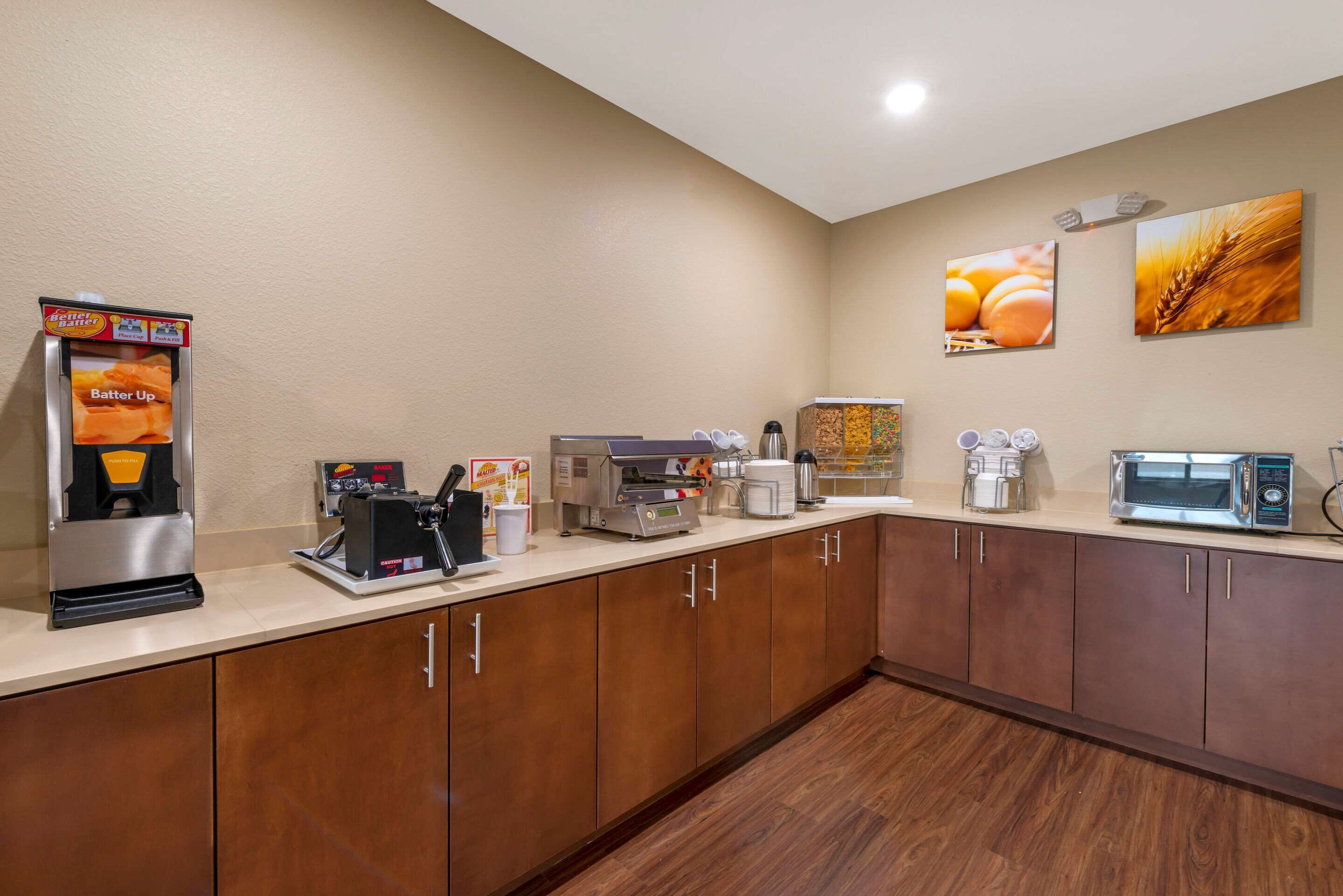 A kitchenette with a coffee machine, toaster, and microwave.