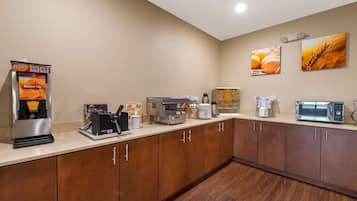 A kitchenette with a coffee machine, toaster, and microwave.