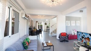 Un soggiorno moderno con divano, tavolino e opere d'arte. Una scala conduce a un altro livello.