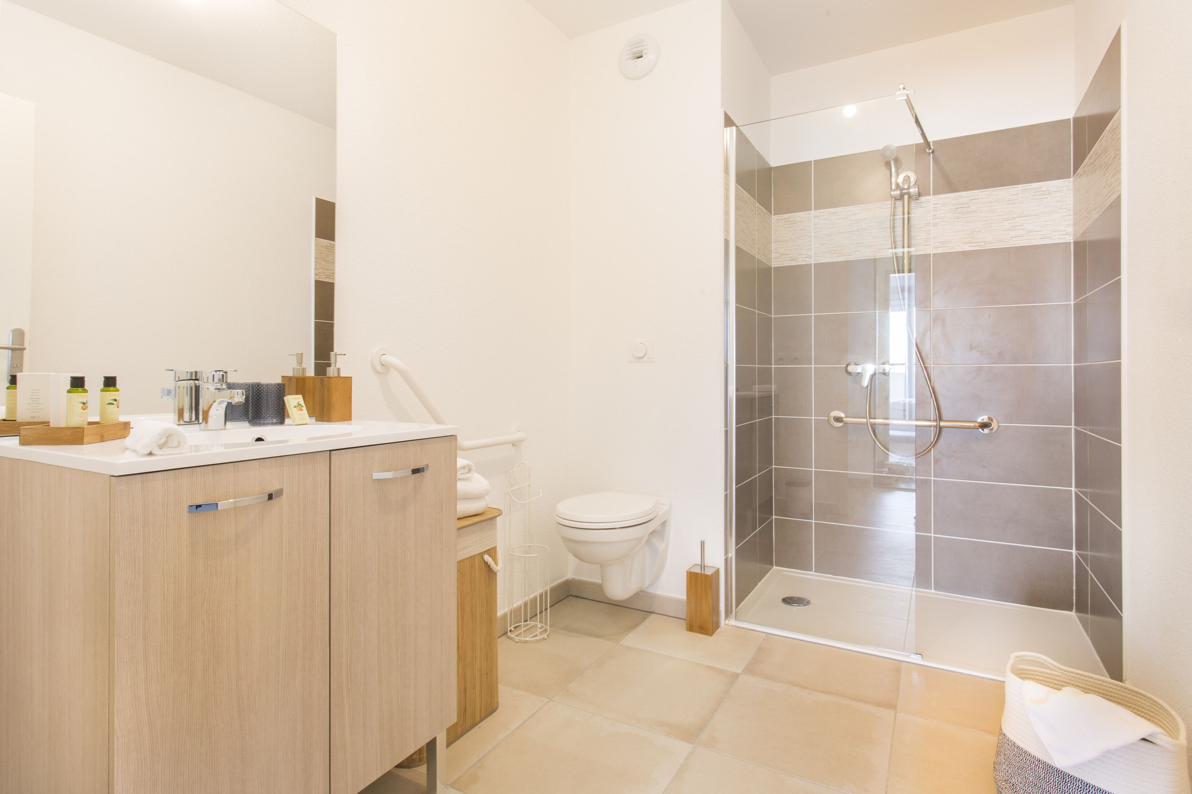 Un baño moderno con ducha, inodoro y tocador.