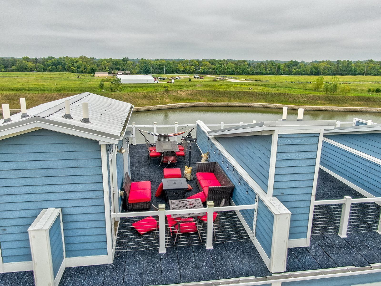 A covered outdoor deck with seating and a view of a green landscape.