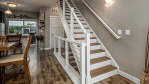 A staircase with white railings and wooden steps leading to an upper floor. - L`il Getaway (Ottawa)