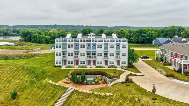 A multi-story residential building with a central courtyard, surrounded by lush greenery and a lake. - L`il Getaway (Ottawa)