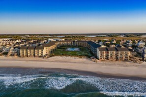 A coastal resort with beachfront villas, a swimming pool, and a beach.