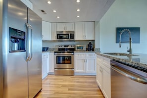 Enjoy cooking in this well-equipped kitchen with a refrigerator, microwave, oven, and dishwasher.