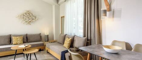 A modern living room with a sofa set, a dining table with chairs, and a floor lamp.
