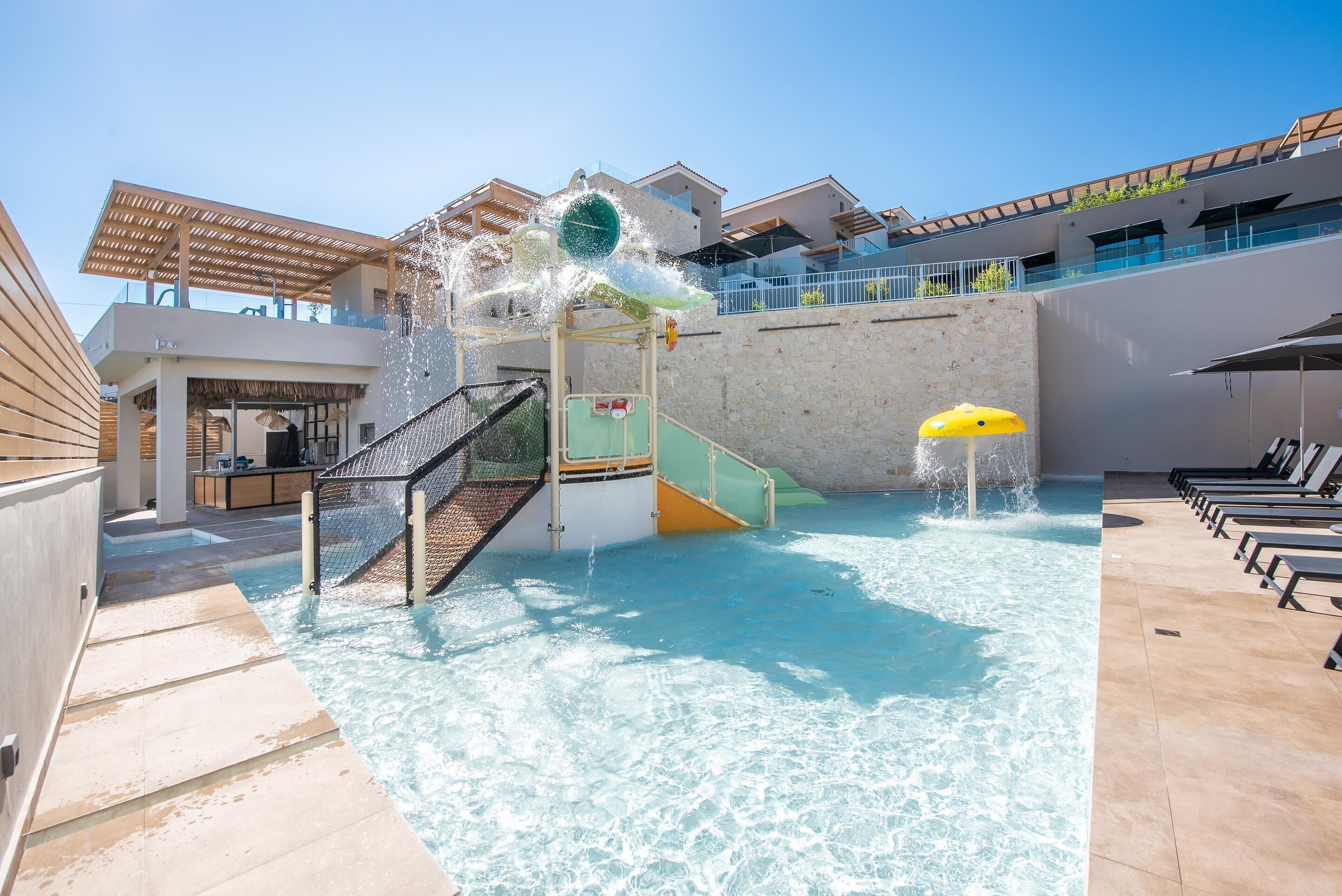 A swimming pool with a water slide, a covered seating area, and a staircase leading to a second level.