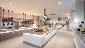 A modern hotel lobby with a central island featuring a buffet, pendant lighting, and a clean, minimalist design. - Caldera Village (Chania)