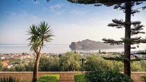 A pathway leading to a scenic overlook with a view of a coastal town and a mountain. - Caldera Village (Chania)