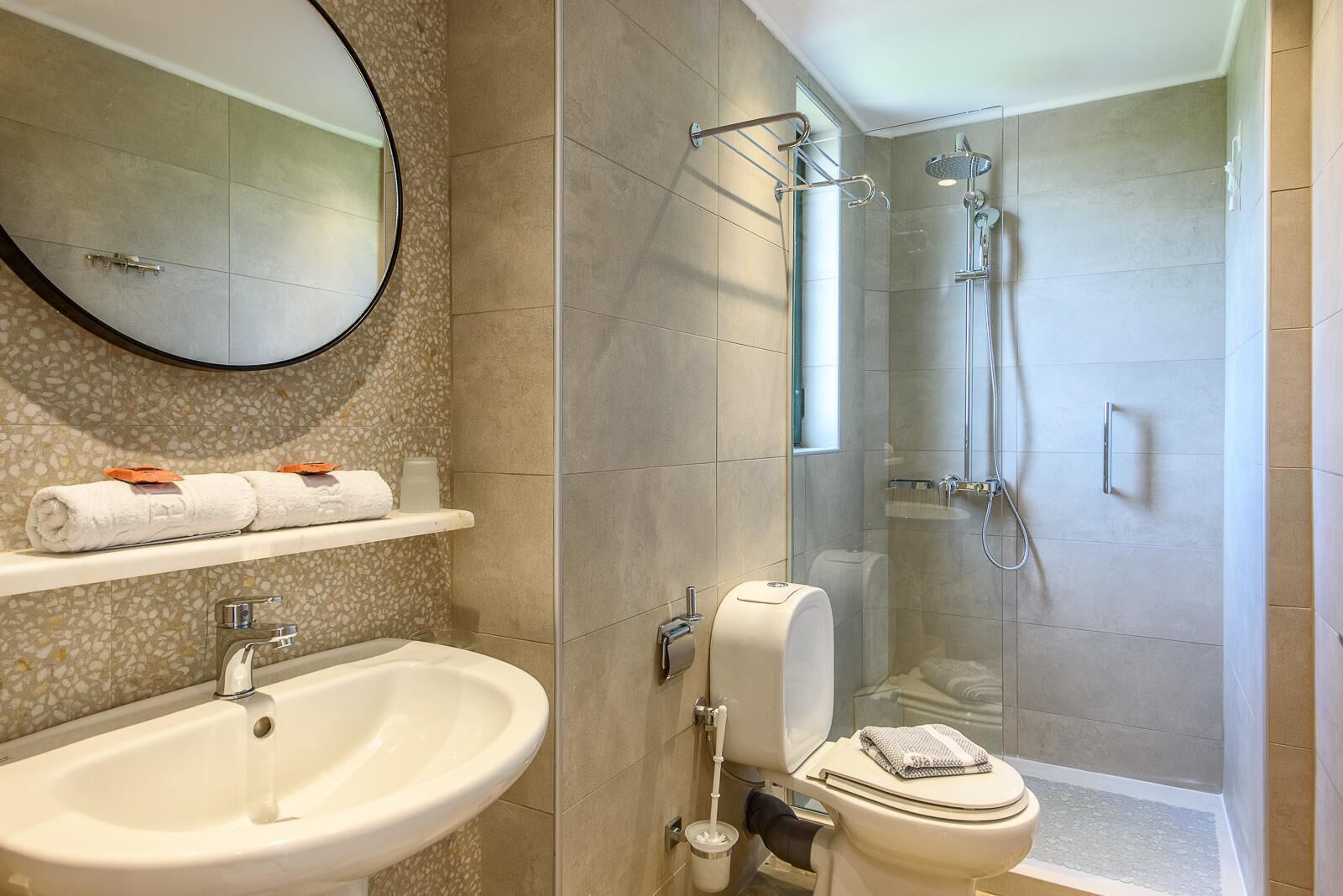 Un baño con lavamanos, inodoro y ducha.