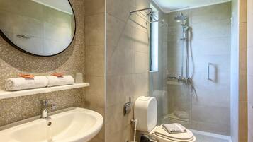 Un baño con lavamanos, inodoro y ducha.
