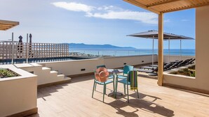 A rooftop terrace with a pool, chairs, and a view of the sea. - Caldera Village (Chania)