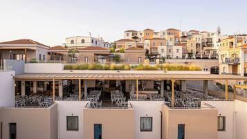 Una terraza en la azotea con mobiliario exterior y vistas de los edificios circundantes.