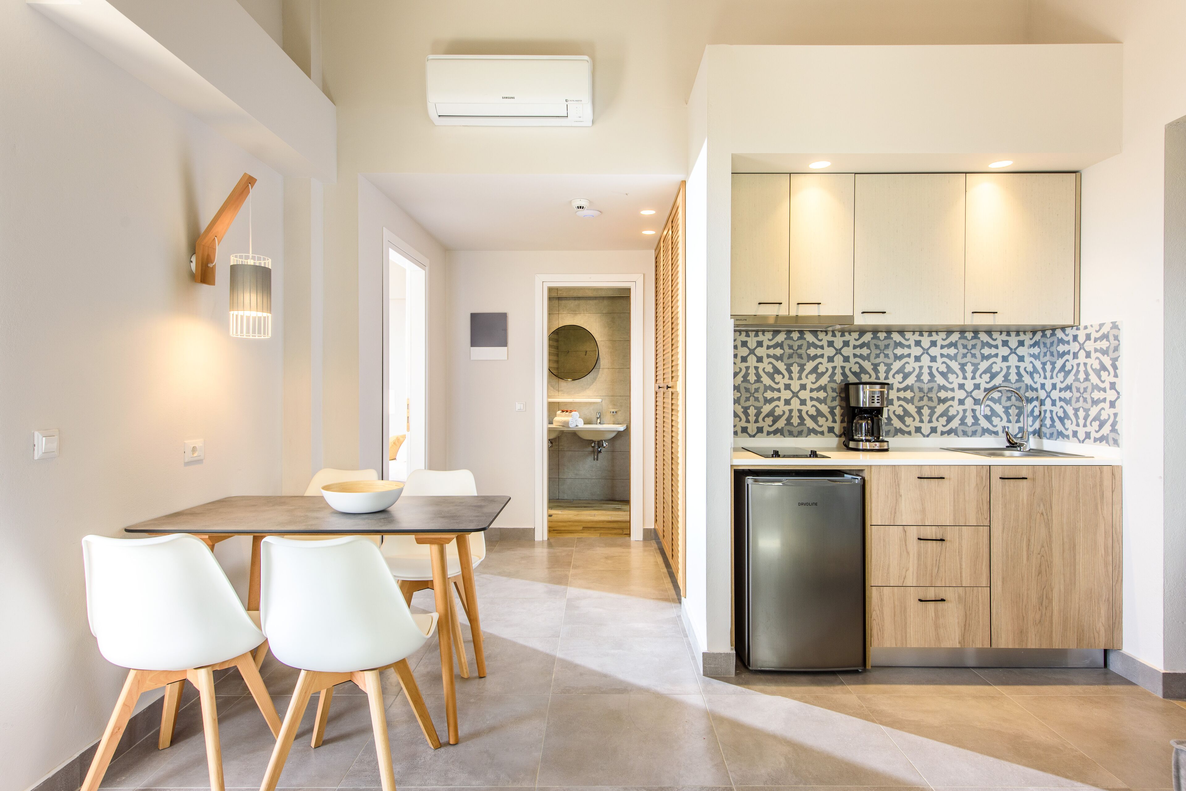 Une cuisine moderne dotée d’un lave-vaisselle encastré, de meubles en bois et d’un crédence décorée.