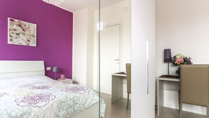 A modern hotel room with a large bed, a desk, and a chair. - Chic Aprtment 10 min to Venice (Mestre)