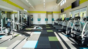 A gym with exercise equipment, treadmills, and a patterned floor.