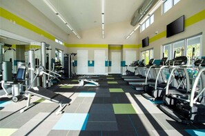 A gym with exercise equipment, treadmills, and a patterned floor.