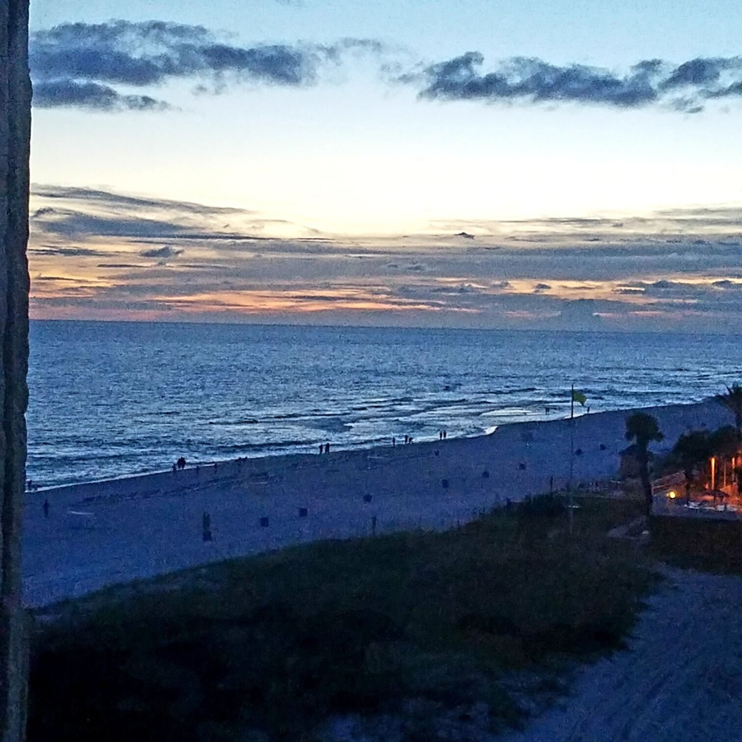 Een kustgezicht met een strand en een zeewering.