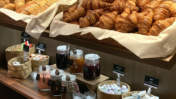 Een bakkerijdisplay met diverse gebakjes en toevoegingen.