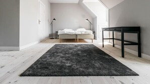 A bedroom with a bed, a desk, and two floor lamps. - 175sqm High-end Luxury Apartment - Heart of CPH (Copenhagen)
