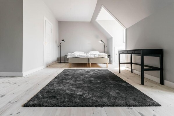 A bedroom with a bed, a desk, and two floor lamps. - 175sqm High-end Luxury Apartment - Heart of CPH (Copenhagen)