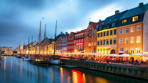 A waterfront promenade with buildings, boats, and outdoor seating areas. - 175sqm High-end Luxury Apartment - Heart of CPH (Copenhagen)