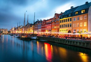 A waterfront promenade with buildings, boats, and outdoor seating areas. - 175sqm High-end Luxury Apartment - Heart of CPH (Copenhagen)
