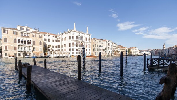 A wooden dock extending into a canal with buildings on the opposite bank. - Fortuny 3967 Luxury Suites Wine - Ve-l736-sanm3967at (Venice)