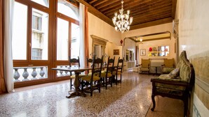 A spacious room with a wooden ceiling, a chandelier, a dining table with chairs, and a sofa. - Fortuny 3967 Luxury Suites Wine - Ve-l736-sanm3967at (Venice)