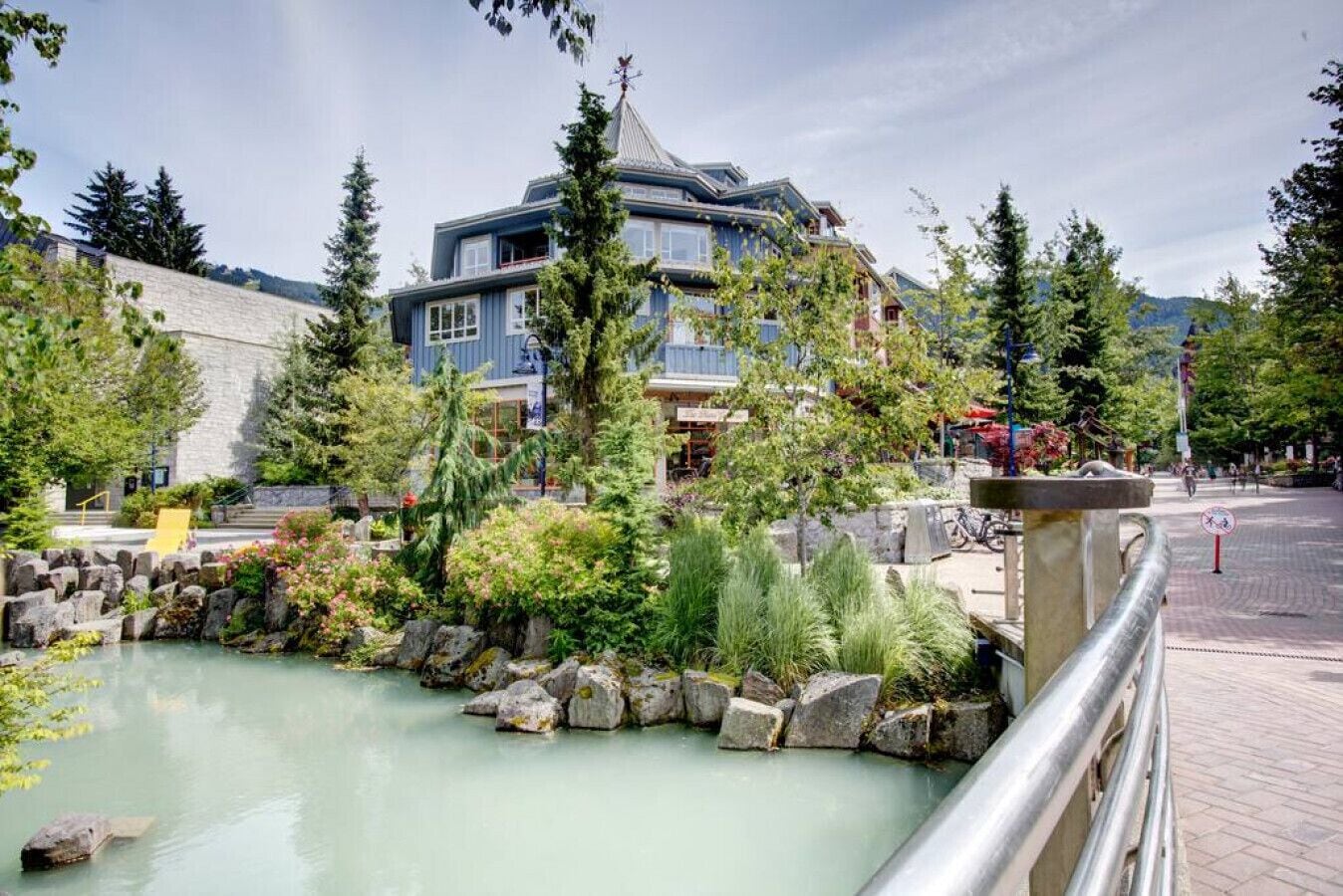 Un hôtel doté d’une piscine, entouré de verdure et délimité par un mur de pierre.