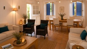 A cozy living room with a sofa, chairs, a coffee table, and a dining area with a table and chairs. - Provençal Villa with Large Pool • 9000 m² of Nature • Total Privacy (Draguignan)