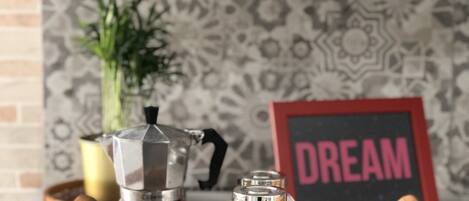 A kitchen counter with a coffee maker, a glass jar, and a tray.