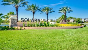 A sign for Solara Resort with palm trees and a well-maintained lawn. - 8967ameila (Kissimmee)