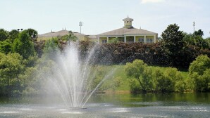 A fountain in a body of water with a building in the background. - 611 Lucaya (Davenport)