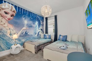 A bedroom with two beds, a mural of a winter scene, a chandelier, and a window with curtains.