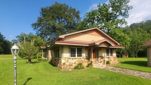 A single-story house with a stone foundation and a red roof. - Eagle's Nest by Table Rock. Perfect for Hickers, Cyclers, and Swimmers. (Sunset)
