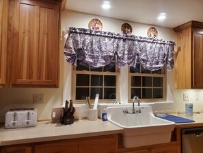 A kitchen with wooden cabinets, a double sink, a toaster, and a knife block. - Eagle's Nest by Table Rock. Perfect for Hickers, Cyclers, and Swimmers. (Sunset)