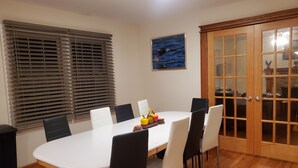 A dining area with a round table, black and white chairs, a fruit bowl, and a painting on the wall. - Eagle's Nest by Table Rock. Perfect for Hickers, Cyclers, and Swimmers. (Sunset)