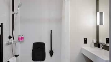 Une salle de bain moderne avec une douche, un porte-serviettes, un siège noir et un lavabo blanc avec un miroir.
