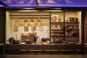 A kitchen with wooden cutting boards hanging, a bread display, and various kitchen appliances. - Moxy Edinburgh (Edinburgh)