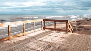 En træterrasse med udsigt over stranden og havet.