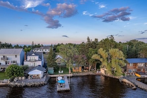 A riverside property with a dock, a small boat, and a cabin labeled 'MOOSE'.