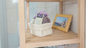 A wooden shelf with a woven basket containing a gift bag and a framed photo. - Small house "BreadLady" (Koper)