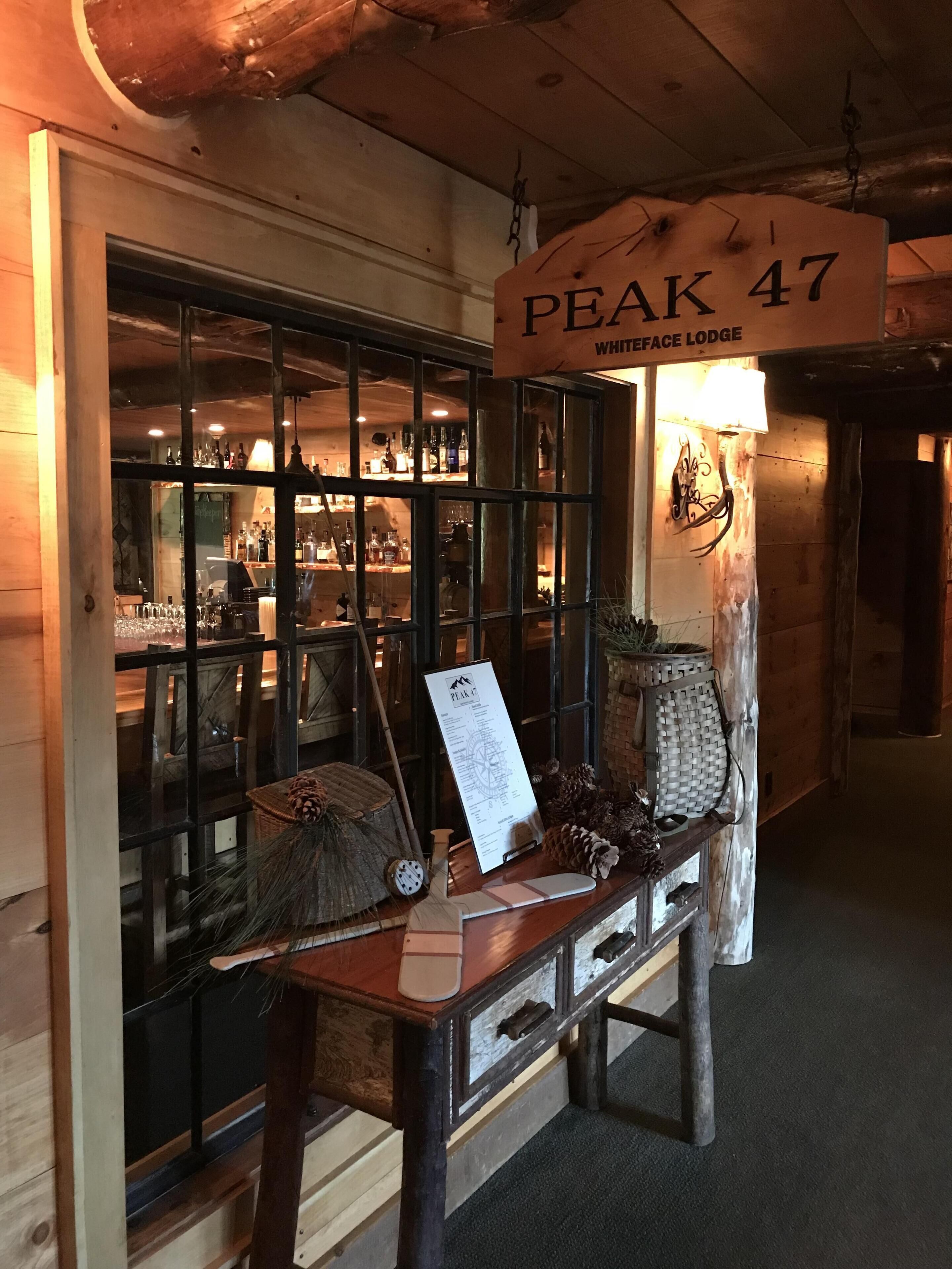 A wooden interior with a sign reading "PEAK 47 WHITEFACE LODGE".