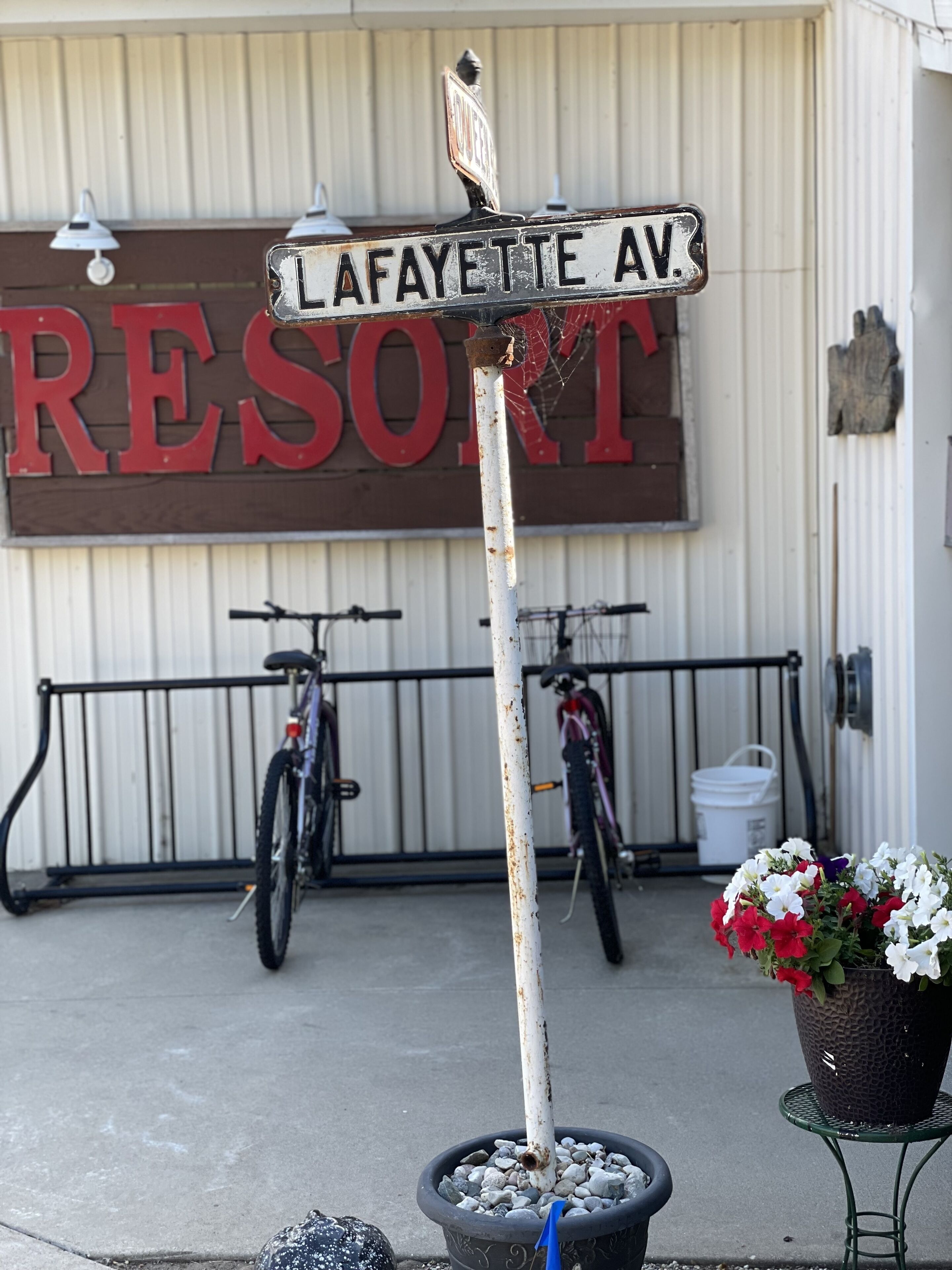 A street sign for Lafayette Avenue in front of a building with a large sign reading "RESORT".