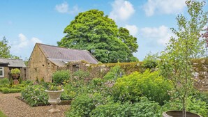 A stone building with a garden in front, a large tree, and a clear sky. - The Studio at Westfield (Bellingham, near Hexham)