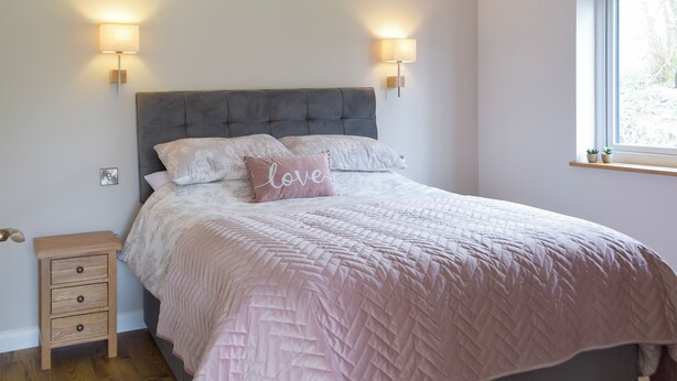 A bedroom with a bed, bedside lamps, a nightstand, and a window. - 2 bedroom accommodation in Cwrt Newydd, near Llandysul (Cwrt Newydd, near Llandysul)