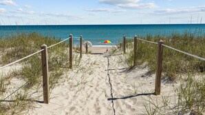 A sandy beach path leading to the ocean with a colorful umbrella. - Maritime West Unit C-33-Ocean Front Condo (Atlantic Beach)
